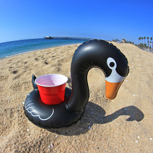 a black duck shaped object on a beach
