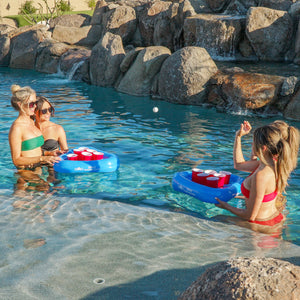 two women in a pool with a ball